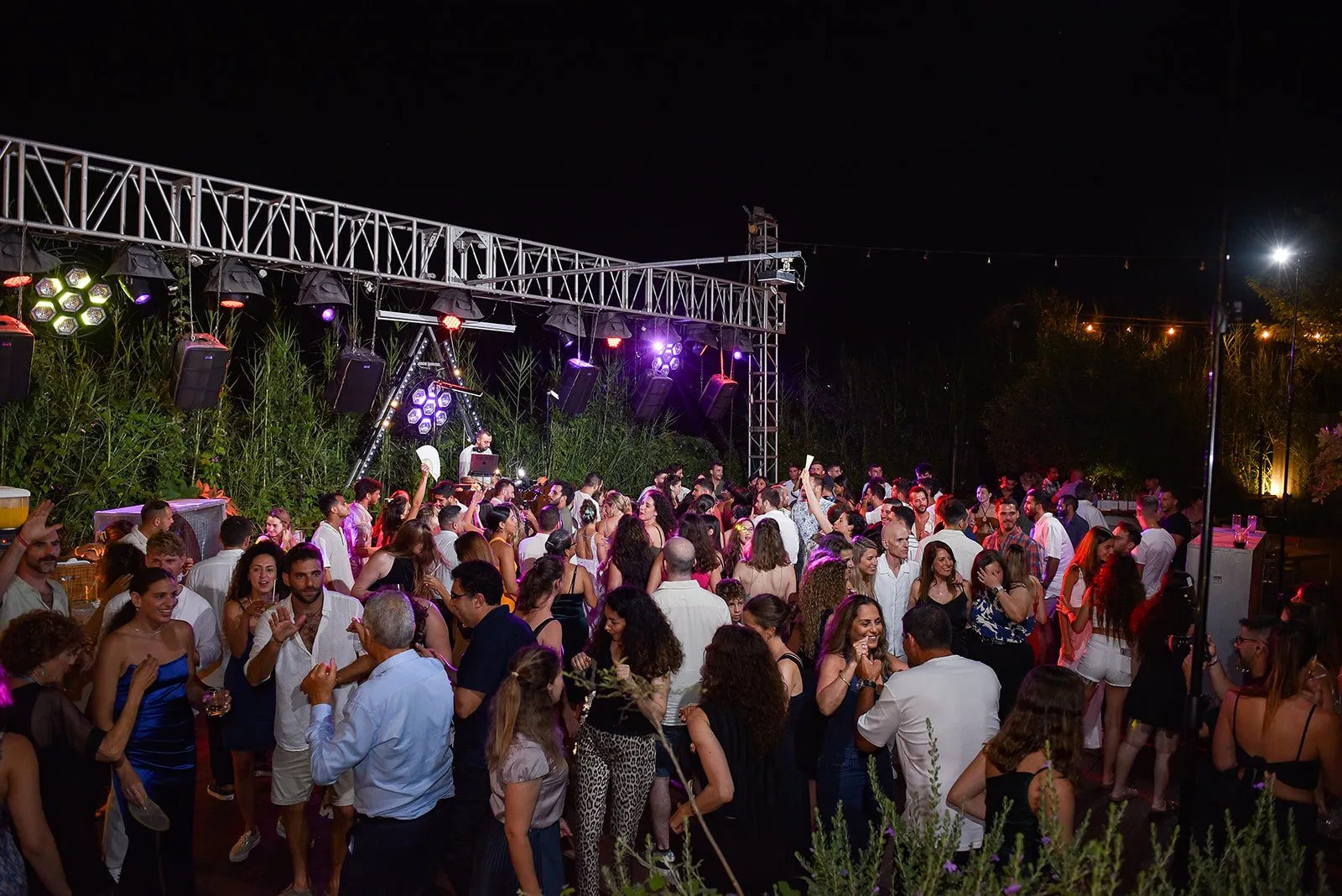 קהל רוקד בתאורה כחולה וסגולה